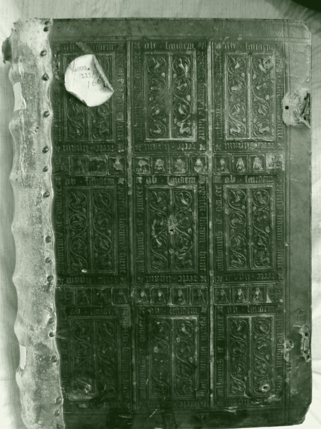 Le plat de cuir d'une reliure ancienne, décoré par estampage à froid : des panneaux de rinceaux enfoncés dans la peau, sans encre ni dorure.